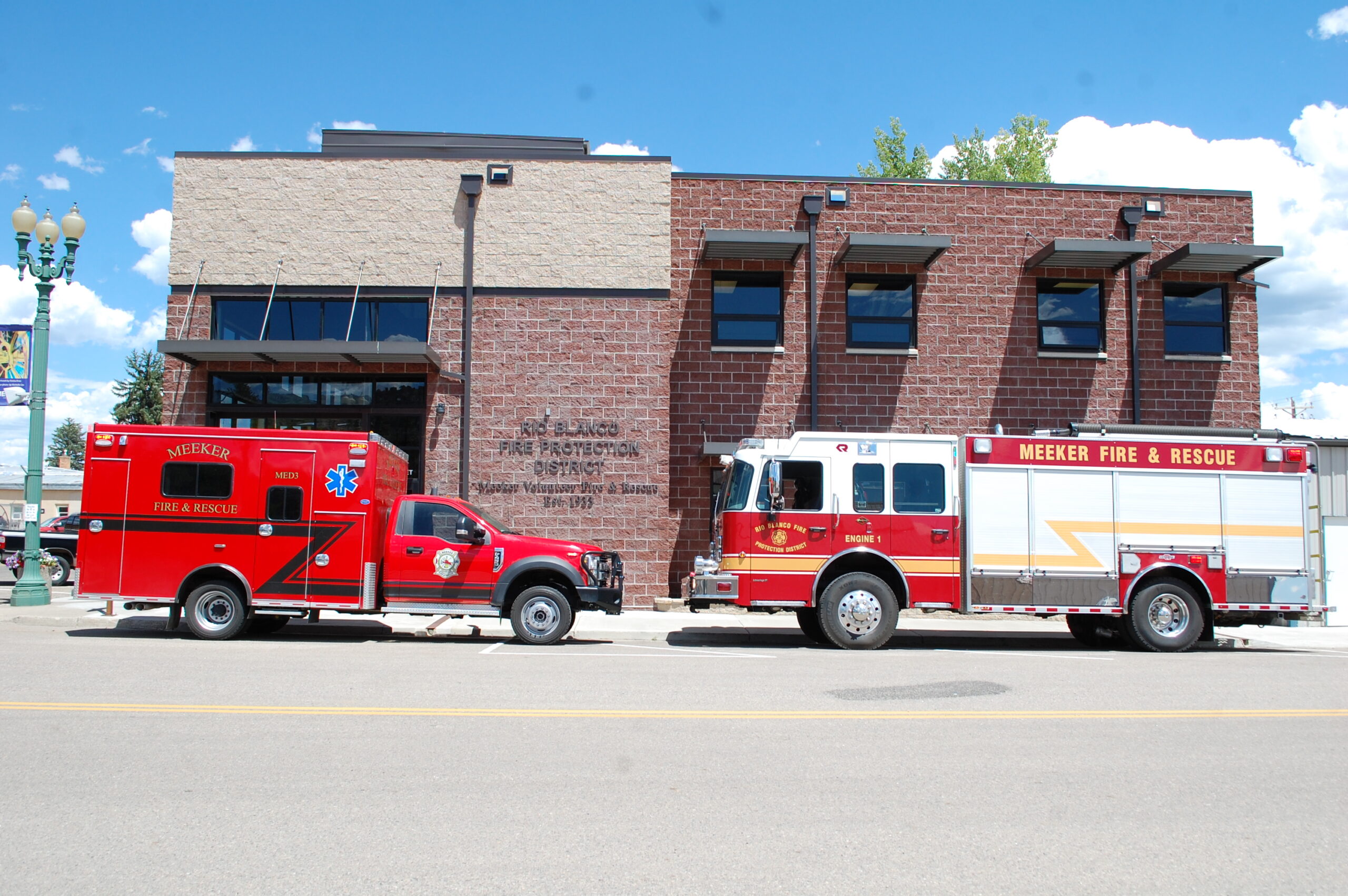 Photo of the Meeker Volunteer Fire Department with fire engine and rescue vehicle parked in front